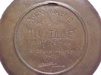 Back of brass John Wayne plate.